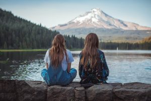 women looking at a lake and mountain