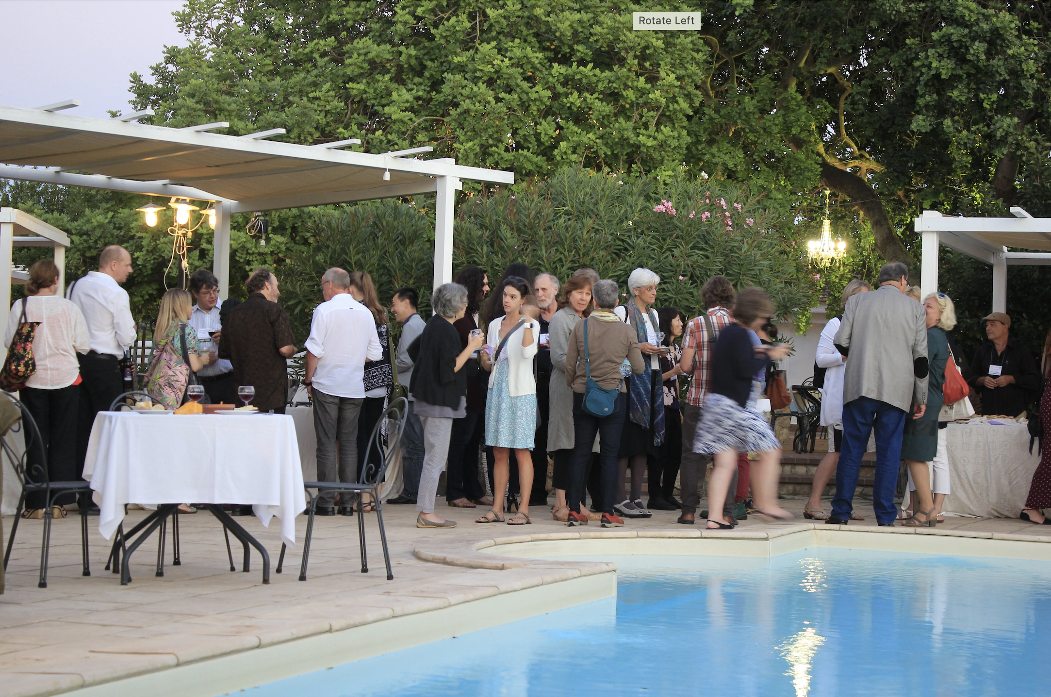 Conference attendees enjoying a social occasion by the pool in Alghero